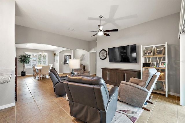 living room with light tile patterned flooring and ceiling fan with notable chandelier