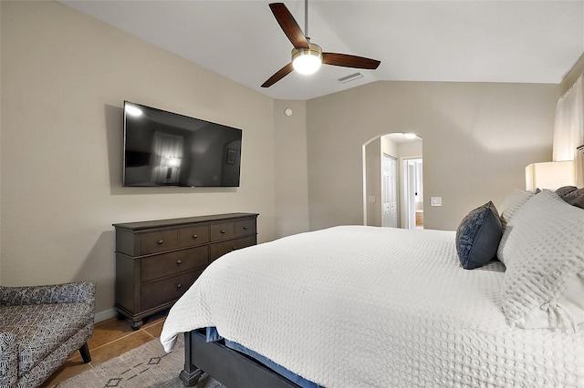 bedroom featuring ceiling fan, light tile patterned floors, and vaulted ceiling