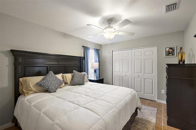 bedroom featuring ceiling fan, light tile patterned flooring, and a closet