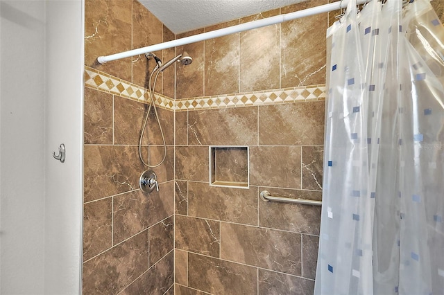 bathroom featuring a shower with shower curtain and a textured ceiling