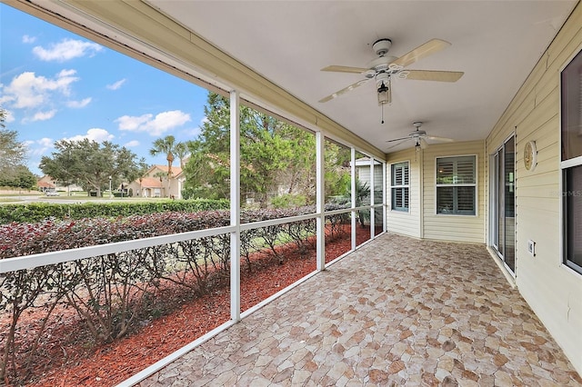 unfurnished sunroom with ceiling fan