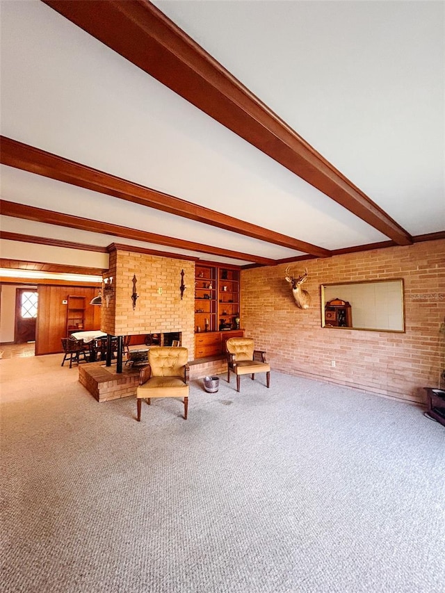 unfurnished living room with carpet flooring, a brick fireplace, built in features, beamed ceiling, and brick wall