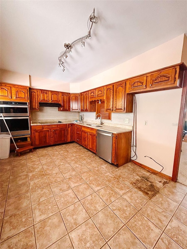 kitchen featuring light tile patterned floors, stainless steel appliances, and sink