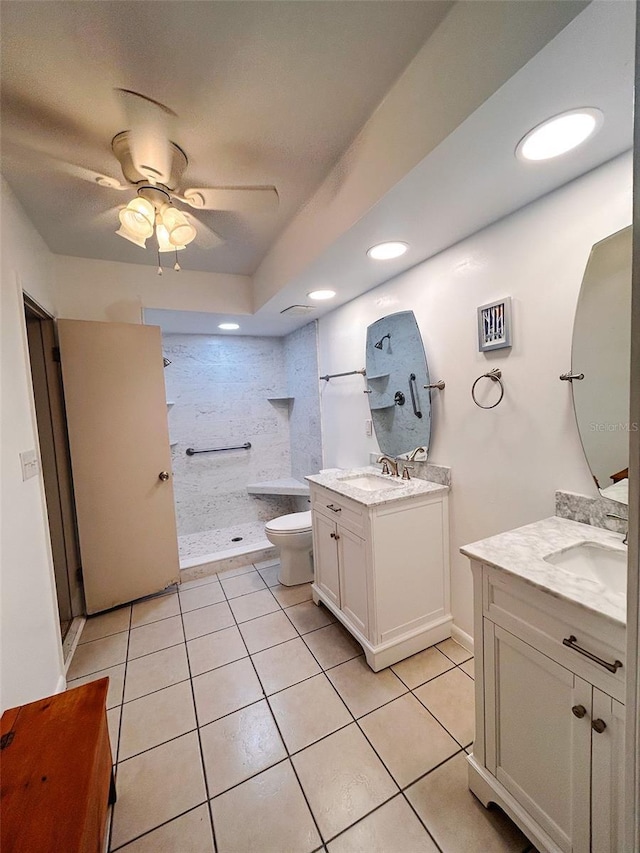 bathroom with vanity, tile patterned floors, ceiling fan, toilet, and a tile shower