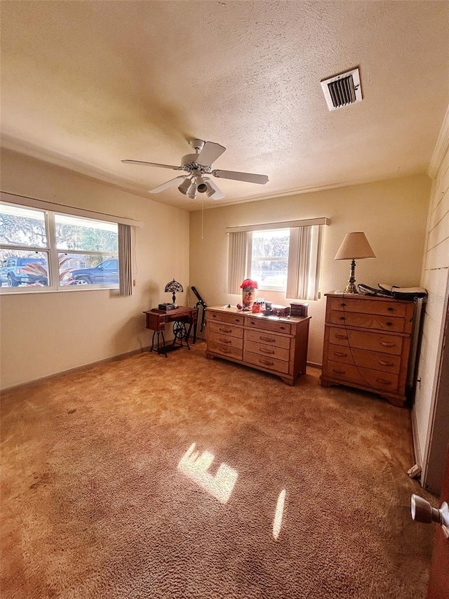 unfurnished bedroom with carpet flooring, ceiling fan, and a textured ceiling