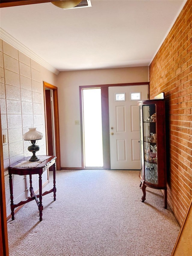 carpeted foyer with ornamental molding