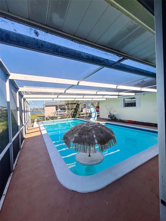 view of swimming pool with a patio, a lanai, and a water slide