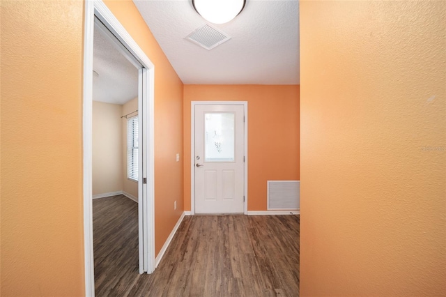 hallway with wood-type flooring and a textured ceiling