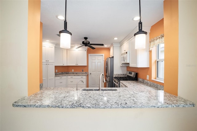 kitchen featuring decorative light fixtures, kitchen peninsula, white cabinets, and stainless steel appliances