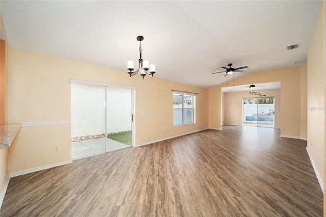 unfurnished living room with hardwood / wood-style flooring, ceiling fan with notable chandelier, and vaulted ceiling