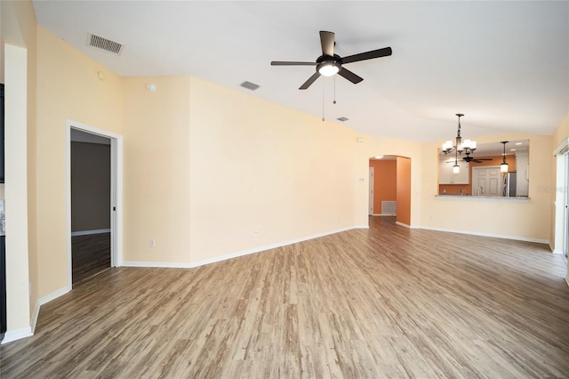 unfurnished living room with ceiling fan with notable chandelier, wood-type flooring, and lofted ceiling