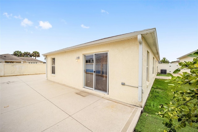 rear view of property featuring a patio and central AC