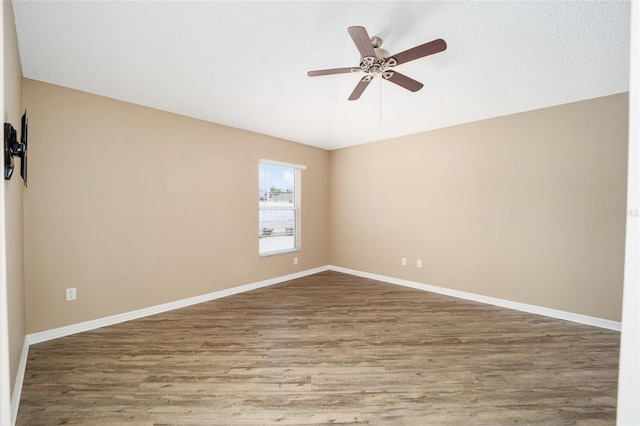 empty room with ceiling fan and wood-type flooring