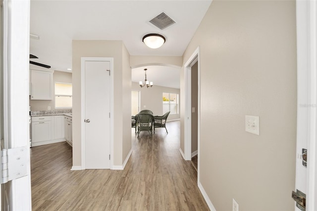 17159 SE 78th Crowfield Ave, The Villages, FL 32162 - hallway with arched walkways, baseboards, light wood finished floors, and visible vents