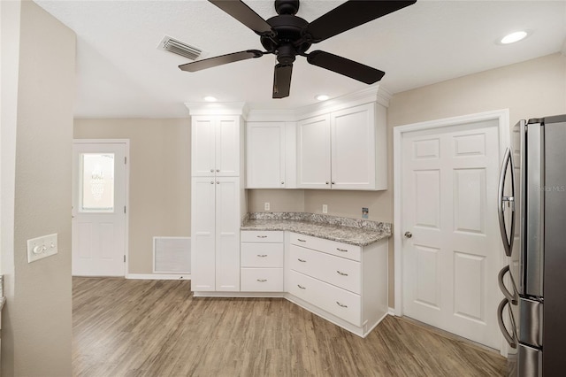 17159 SE 78th Crowfield Ave, The Villages, FL 32162 - kitchen with visible vents, light wood-style floors, and freestanding refrigerator
