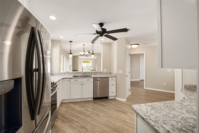 17159 SE 78th Crowfield Ave, The Villages, FL 32162 - kitchen with ceiling fan, appliances with stainless steel finishes, white cabinetry, a sink, and light wood-style floors