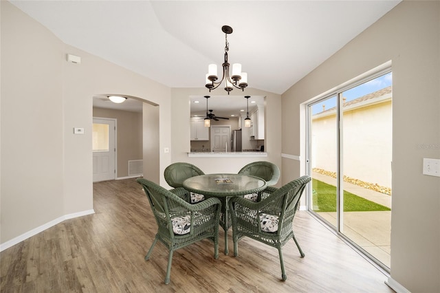 17159 SE 78th Crowfield Ave, The Villages, FL 32162 - dining room featuring visible vents, arched walkways, lofted ceiling, and light wood-type flooring