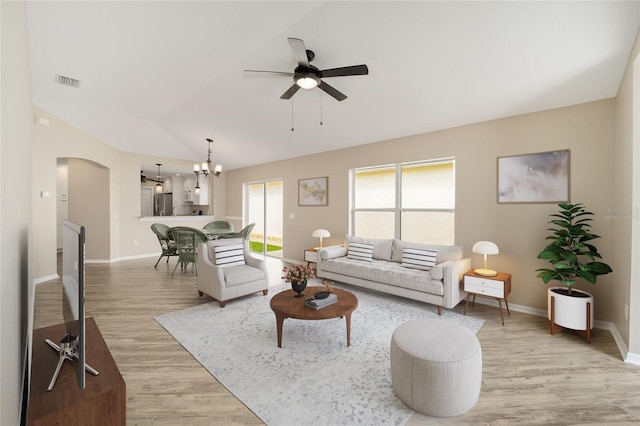 17159 SE 78th Crowfield Ave, The Villages, FL 32162 - living area with lofted ceiling, light wood-type flooring, ceiling fan with notable chandelier, baseboards, and arched walkways