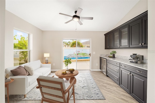 17159 SE 78th Crowfield Ave, The Villages, FL 32162 - living area with wine cooler, lofted ceiling, light wood-style flooring, baseboards, and ceiling fan