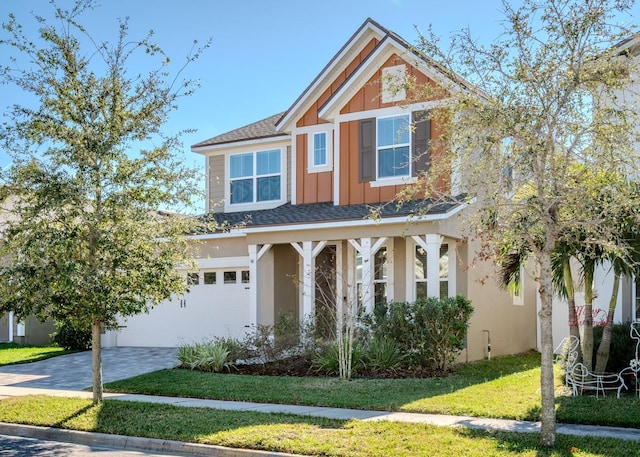 craftsman inspired home with a garage and a front yard