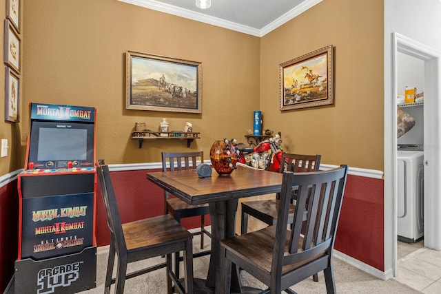 tiled dining space featuring crown molding and washer / dryer