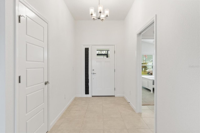 tiled entrance foyer with a notable chandelier