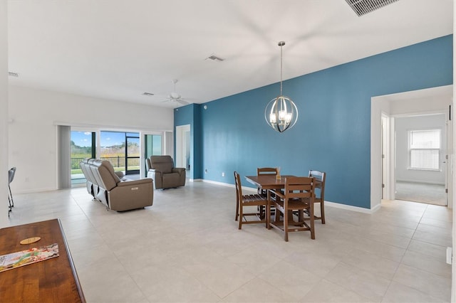 dining space featuring ceiling fan with notable chandelier