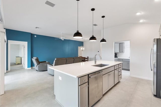 kitchen featuring gray cabinetry, sink, hanging light fixtures, stainless steel appliances, and a center island with sink