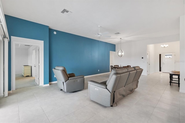 living room with ceiling fan with notable chandelier and light tile patterned flooring