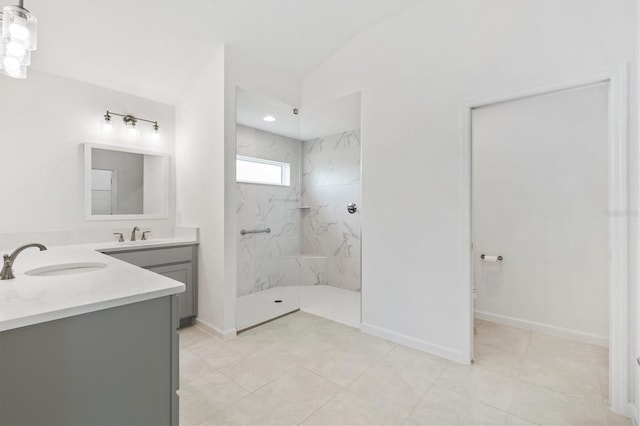 bathroom featuring tile patterned flooring, vanity, a tile shower, and lofted ceiling