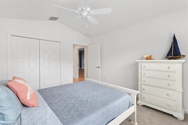 carpeted bedroom featuring ceiling fan, vaulted ceiling, and a closet