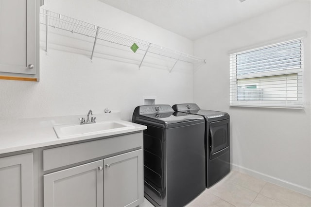 laundry room featuring cabinets, sink, light tile patterned floors, and washer and dryer