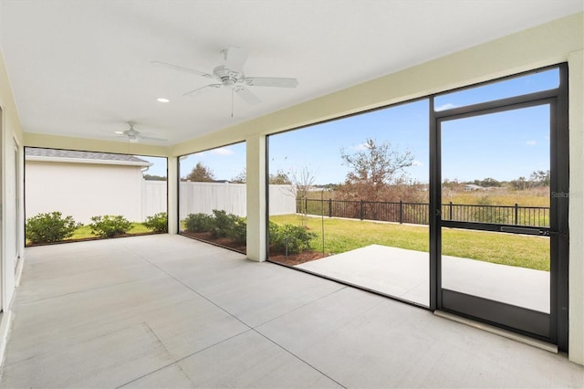 unfurnished sunroom with ceiling fan