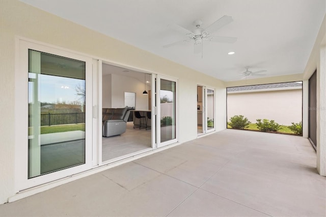 unfurnished sunroom featuring ceiling fan