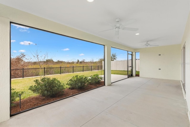 unfurnished sunroom with ceiling fan