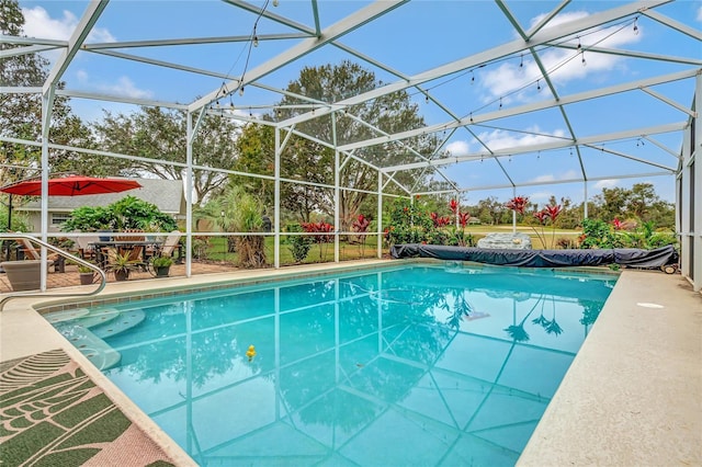 view of pool featuring glass enclosure and a patio area