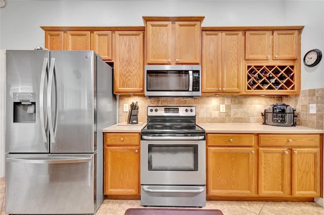 kitchen with stainless steel appliances, tasteful backsplash, and light tile patterned floors