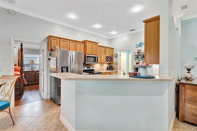 kitchen with stainless steel appliances, ornamental molding, light tile patterned floors, and kitchen peninsula