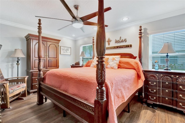 bedroom with multiple windows, hardwood / wood-style floors, ornamental molding, and ceiling fan