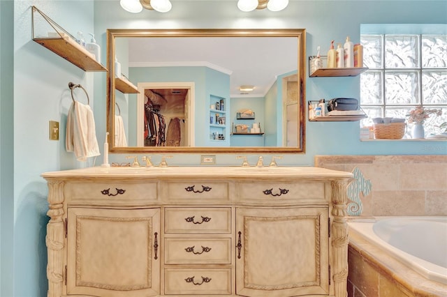 bathroom with ornamental molding, tiled bath, and vanity