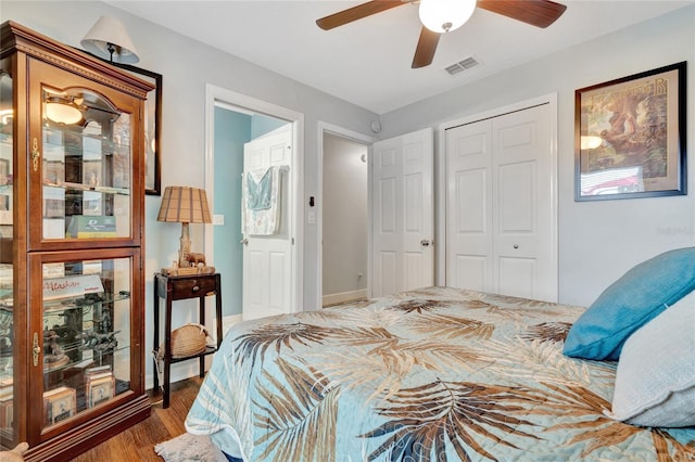 bedroom with a closet, dark hardwood / wood-style floors, and ceiling fan