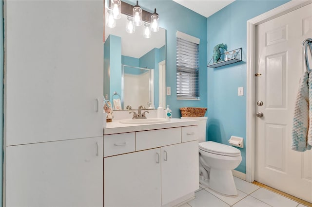 bathroom featuring tile patterned floors, toilet, a shower with door, and vanity