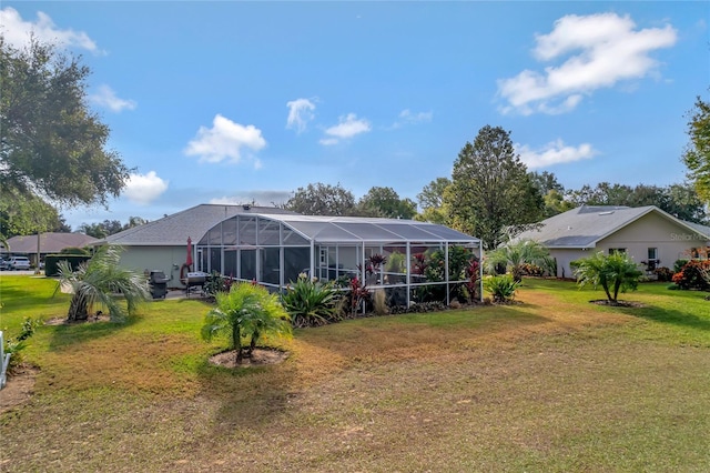 rear view of property with a yard and glass enclosure