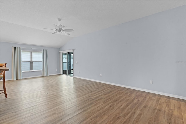 spare room featuring a textured ceiling, ceiling fan, light hardwood / wood-style flooring, and vaulted ceiling