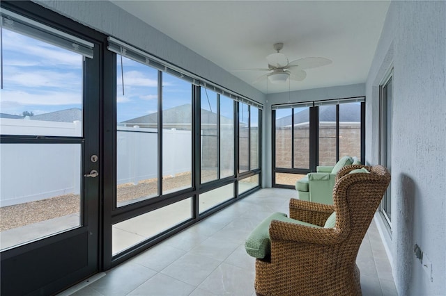 sunroom / solarium with a mountain view and ceiling fan