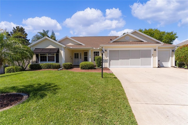 ranch-style house featuring driveway, an attached garage, and a front yard