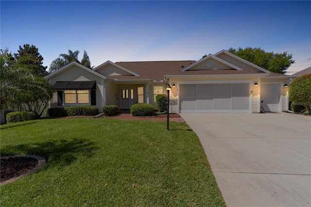 view of front of house featuring a garage and a front lawn