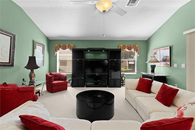 carpeted living room featuring ceiling fan, vaulted ceiling, and a textured ceiling