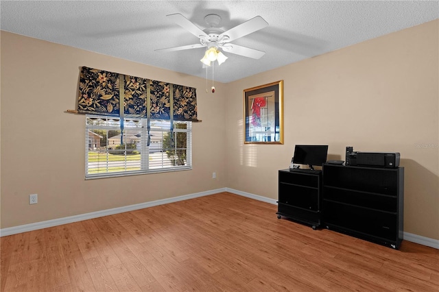 interior space with a textured ceiling, wood-type flooring, and ceiling fan