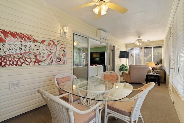 dining space with crown molding, ceiling fan, carpet flooring, a wall mounted air conditioner, and a textured ceiling